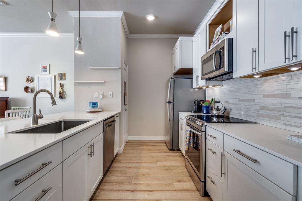 2305 Worthington Street, Unit 104 Dallas, TX 75204 - Photo 5 of 25 a kitchen with stainless steel appliances granite countertop a sink and cabinets