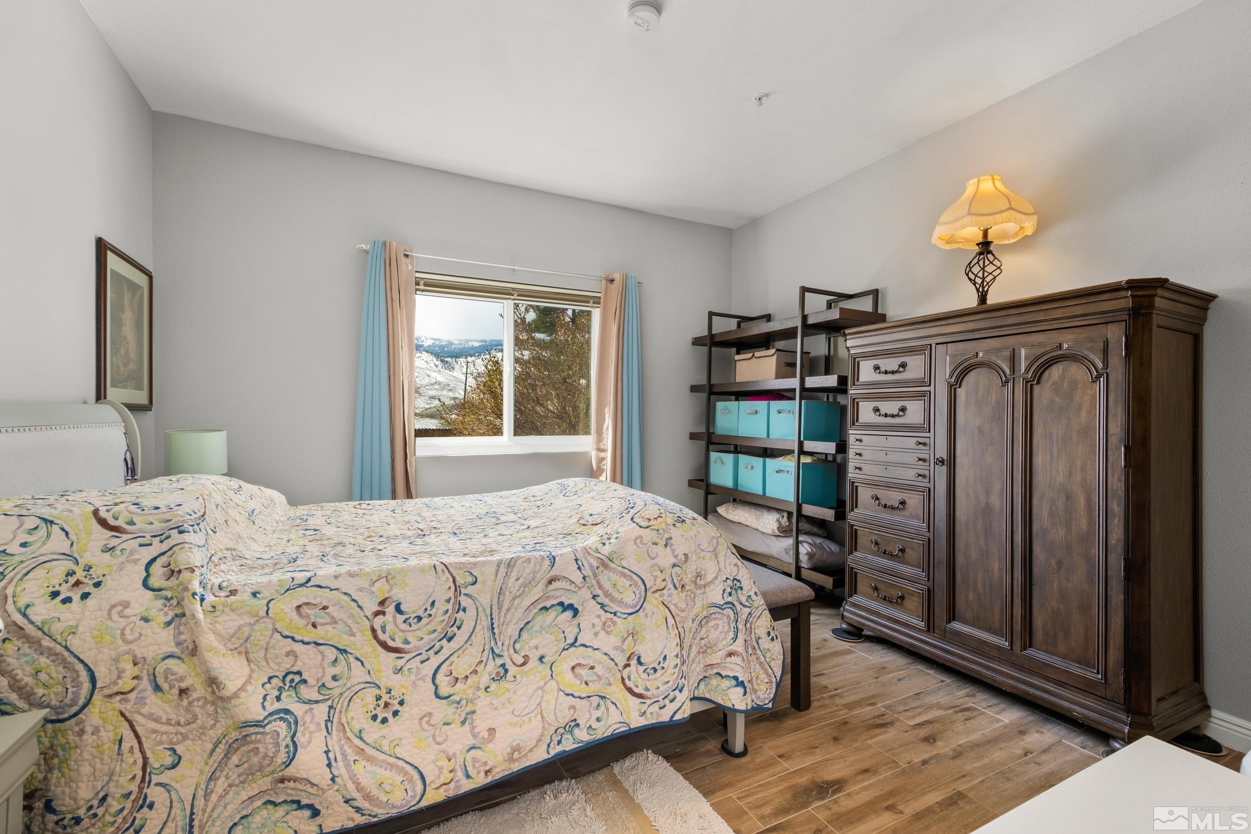 6850 Sharlands Avenue, Unit 1100 Reno, NV 89523 - Photo 26 of 26 a bedroom with a bed and a dresser with bookshelf