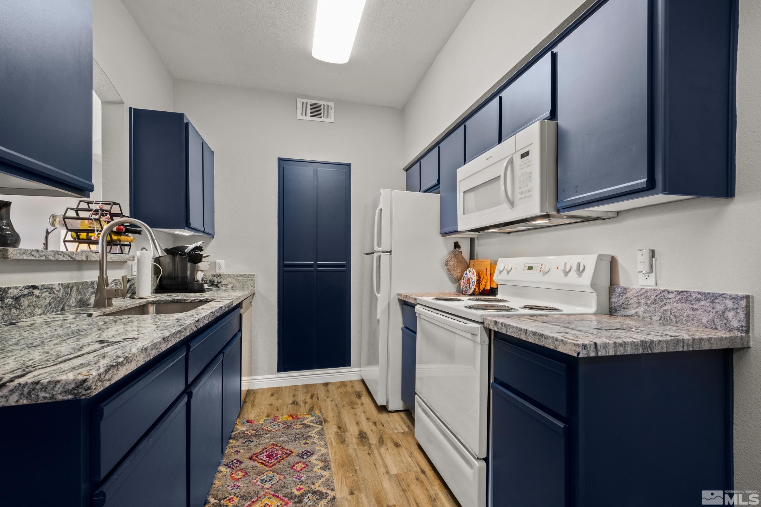 6850 Sharlands Avenue, Unit 1100 Reno, NV 89523 - Photo 6 of 26 a kitchen with stainless steel appliances granite countertop a sink stove and refrigerator