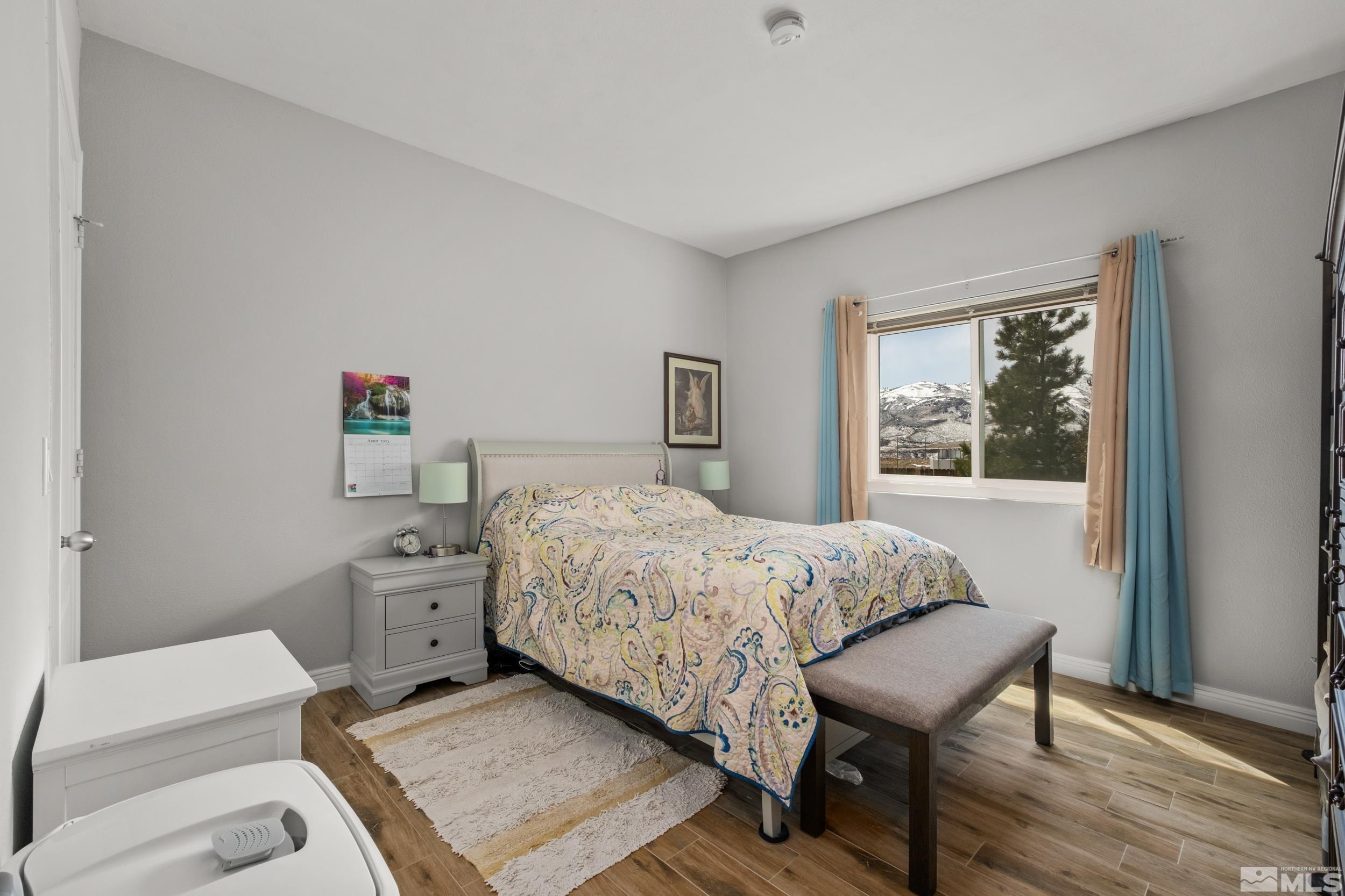 6850 Sharlands Avenue, Unit 1100 Reno, NV 89523 - Photo 9 of 26 a bedroom with a bed and wooden floor