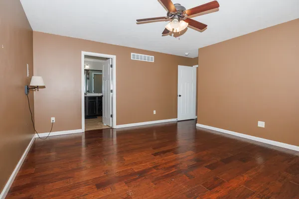 a view of an empty room with wooden floor