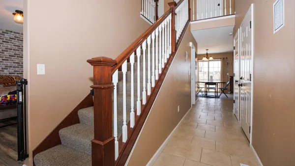 a view of a hallway with wooden floor and stairs