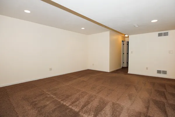 an empty room with wooden floor and entrance