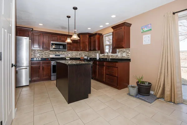 a kitchen with stainless steel appliances granite countertop a stove and a refrigerator
