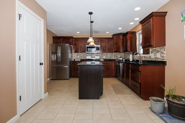 a kitchen with stainless steel appliances granite countertop a stove a refrigerator a sink and dishwasher