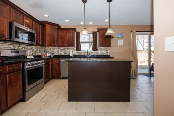 a kitchen with stainless steel appliances granite countertop a stove a sink and a refrigerator