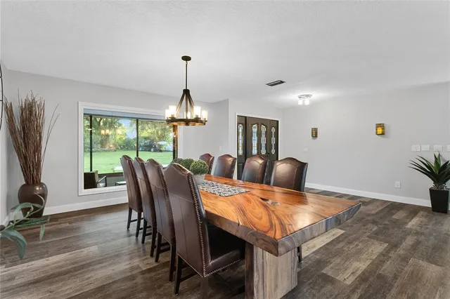 a view of a dining room with furniture a chandelier and wooden floor
