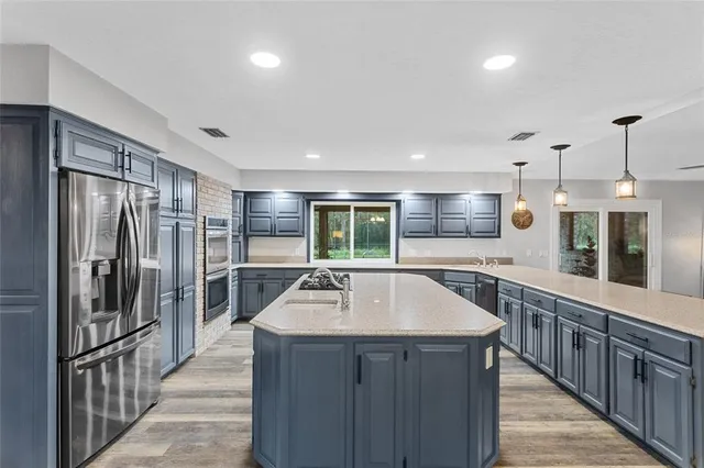 a kitchen with stainless steel appliances granite countertop a sink stove and refrigerator
