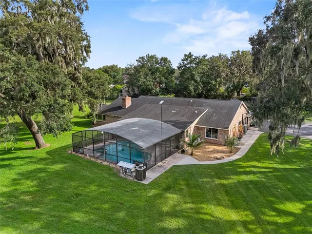 an aerial view of a house with garden space and trees