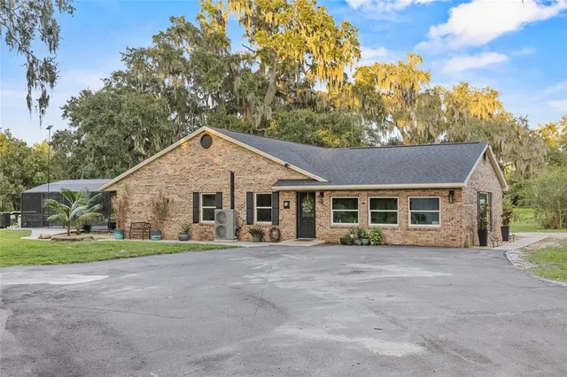 a view of house with a yard and potted plants