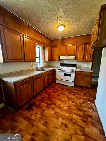 a kitchen with stainless steel appliances granite countertop a stove sink and cabinets
