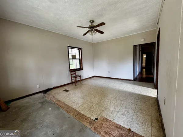 an empty room with a ceiling fan and window