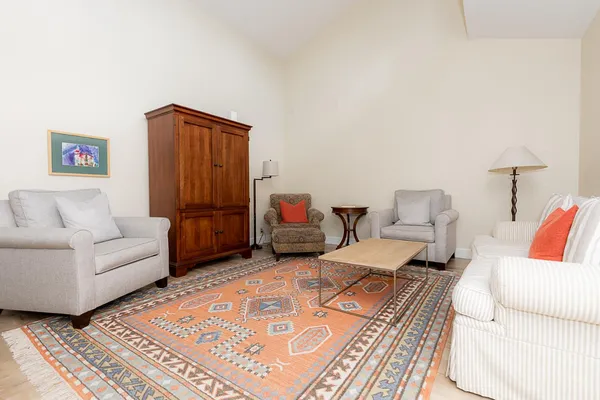 a living room with furniture a rug and a table