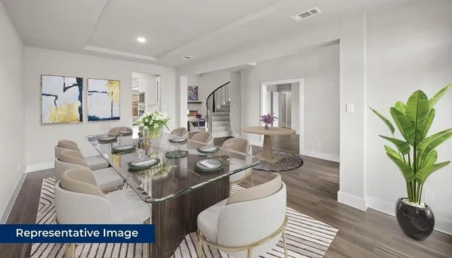a living room with furniture a potted plant and open kitchen view