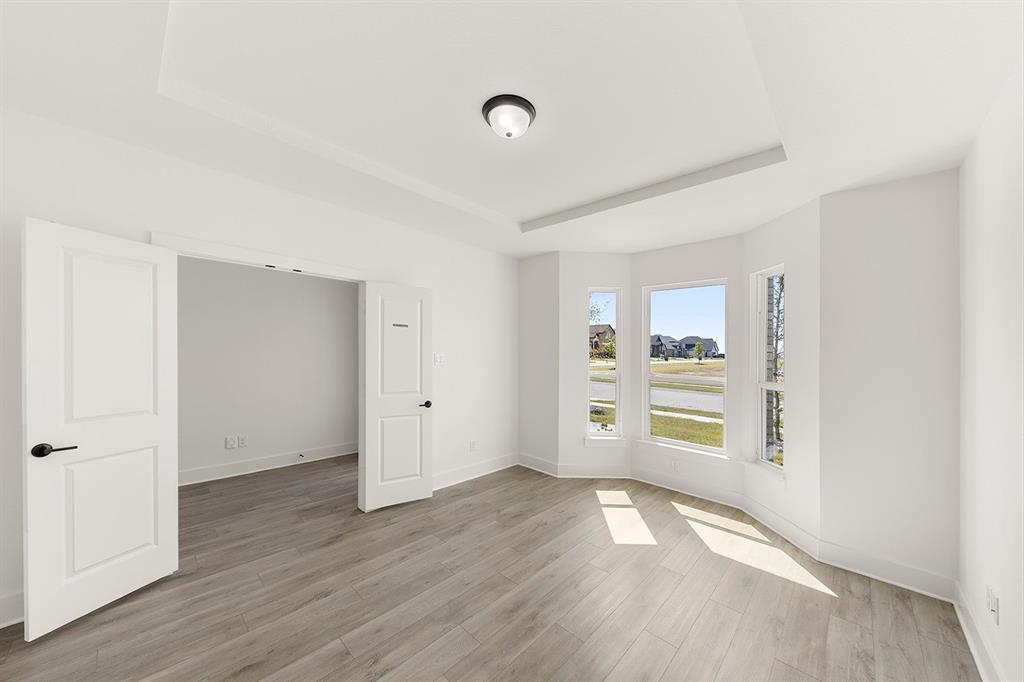9621 Chesney Drive Forney, TX 75126 - Photo 17 of 36 an empty room with wooden floor and windows