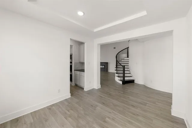 an empty room with wooden floor and white walls