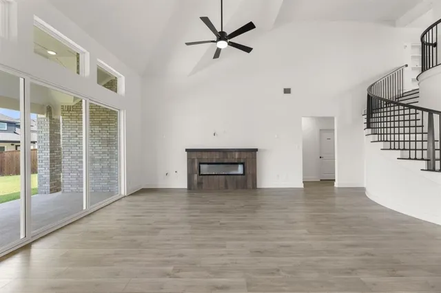 a view of an empty room with a ceiling fan and window