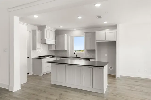 a kitchen with stainless steel appliances granite countertop a sink and cabinets