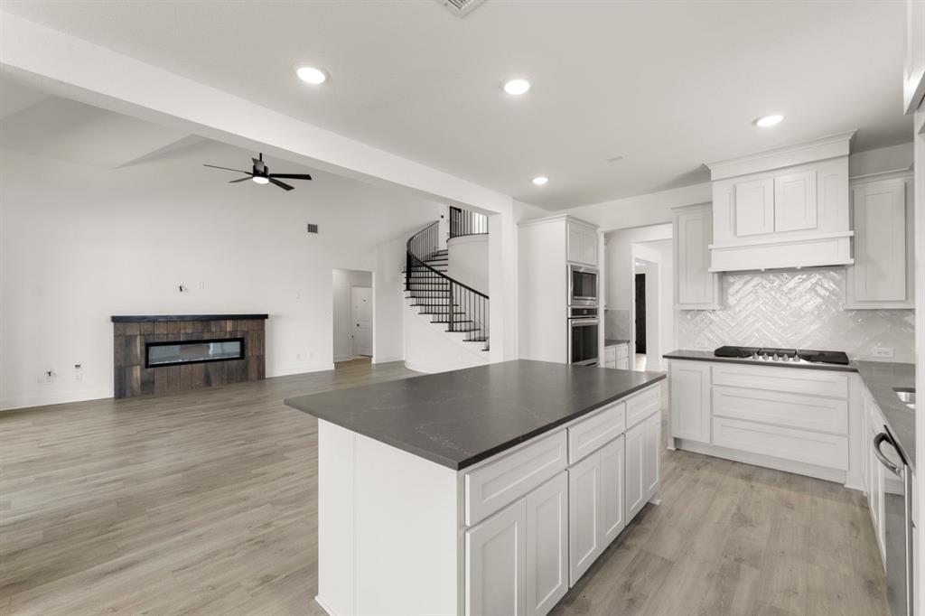 9621 Chesney Drive Forney, TX 75126 - Photo 24 of 36 a kitchen that has a lot of cabinets in it and wooden floors