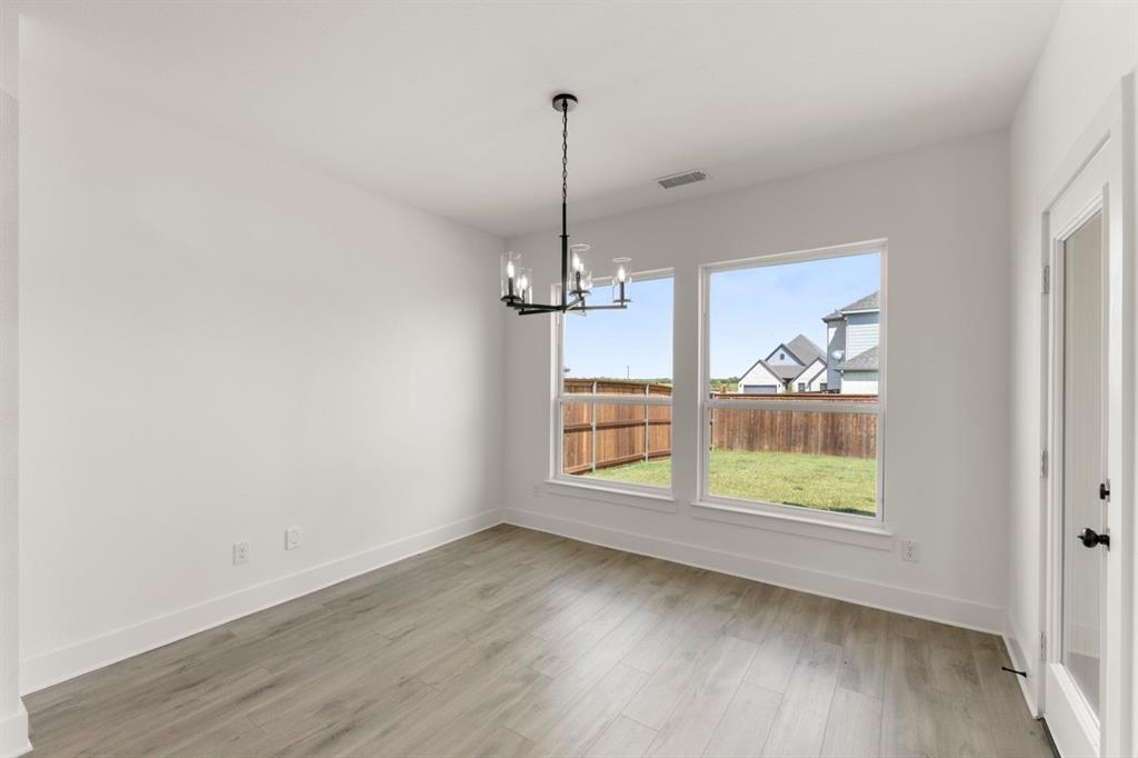 9621 Chesney Drive Forney, TX 75126 - Photo 26 of 36 an empty room with wooden floor a ceiling fan and windows