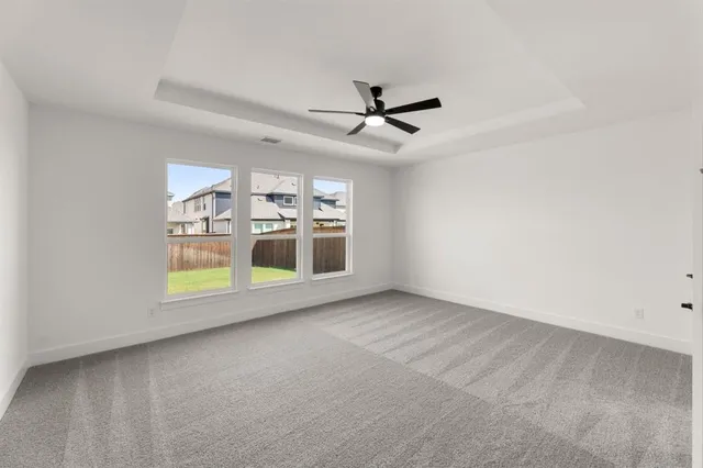 an empty room with windows and ceiling fan view