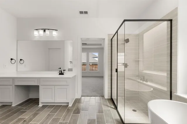 a spacious bathroom with a shower a sink and a mirror