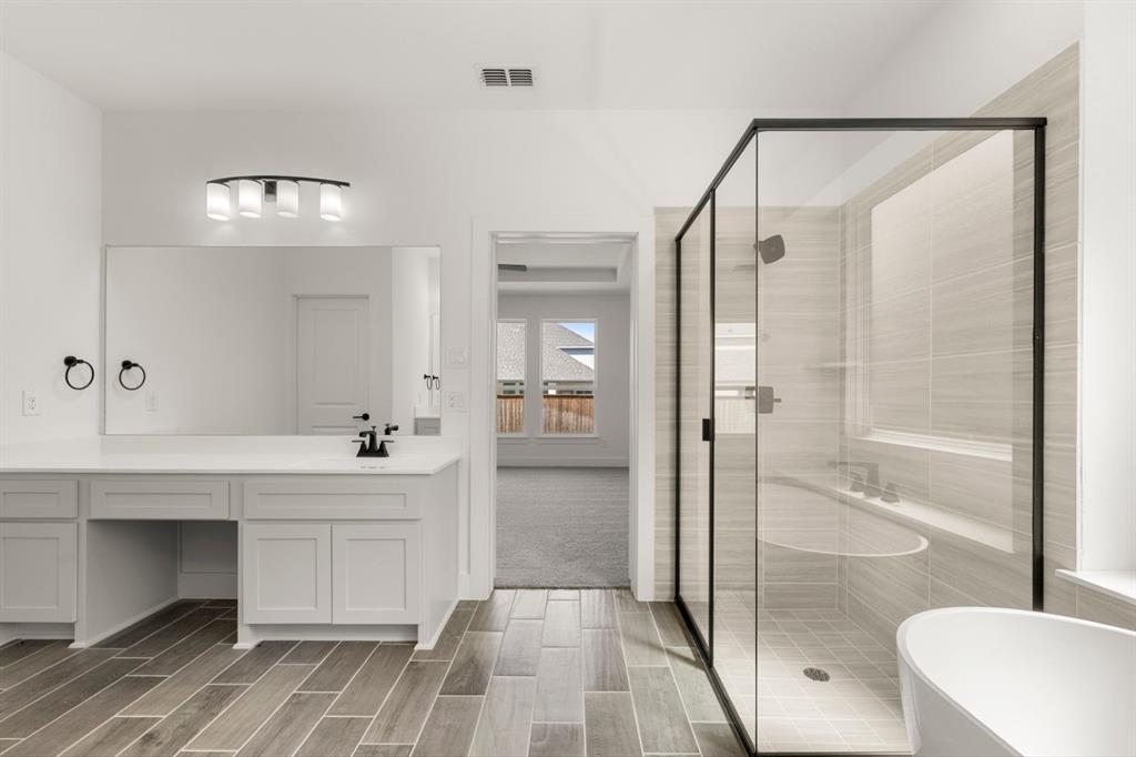 9621 Chesney Drive Forney, TX 75126 - Photo 34 of 36 a spacious bathroom with a shower a sink and a mirror
