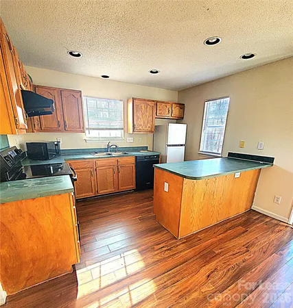 a large kitchen with stainless steel appliances granite countertop a stove a sink and a refrigerator