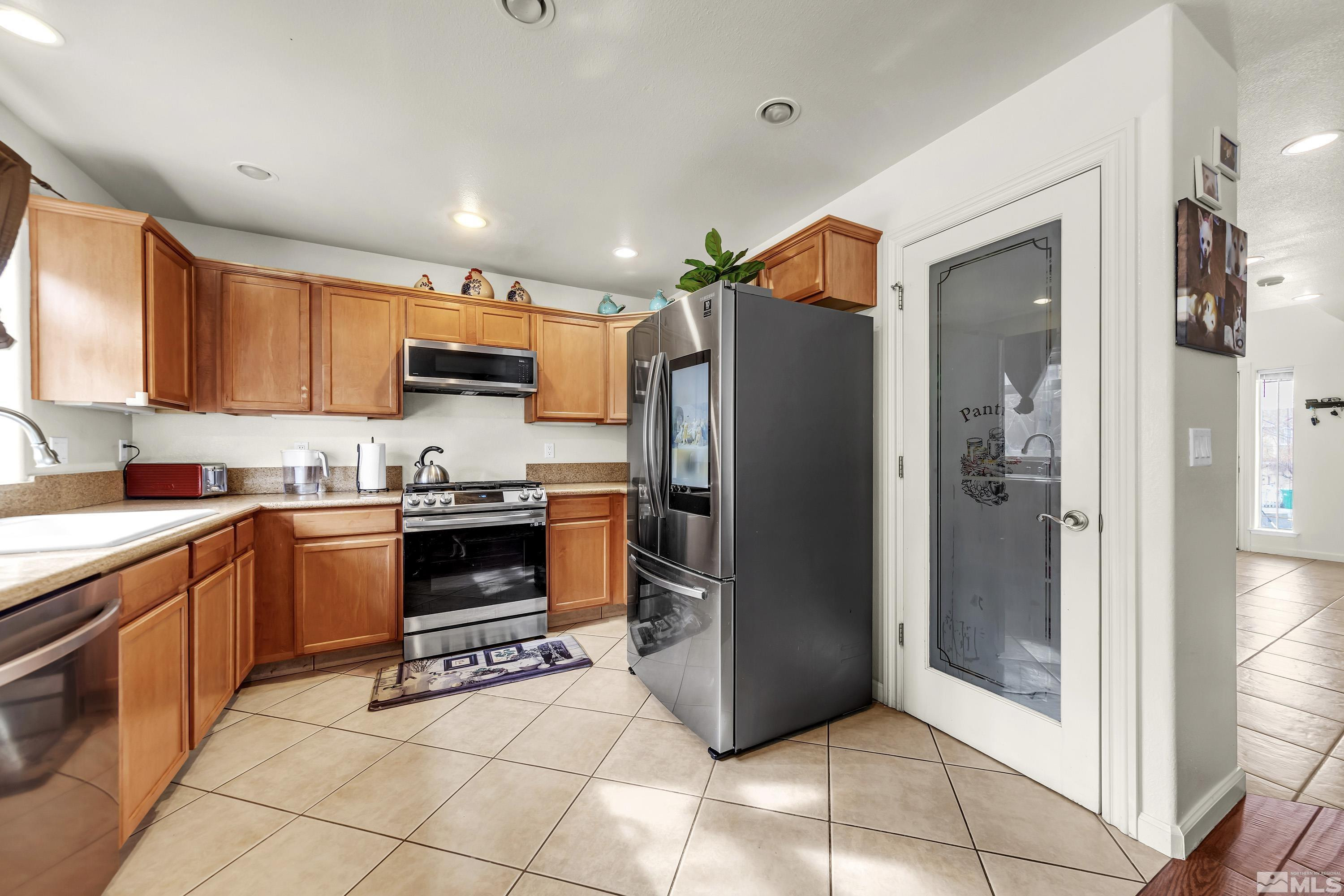 6750 Peppermint Court Reno, NV 89506 - Photo 12 of 33 a kitchen with stainless steel appliances granite countertop a refrigerator and a stove top oven
