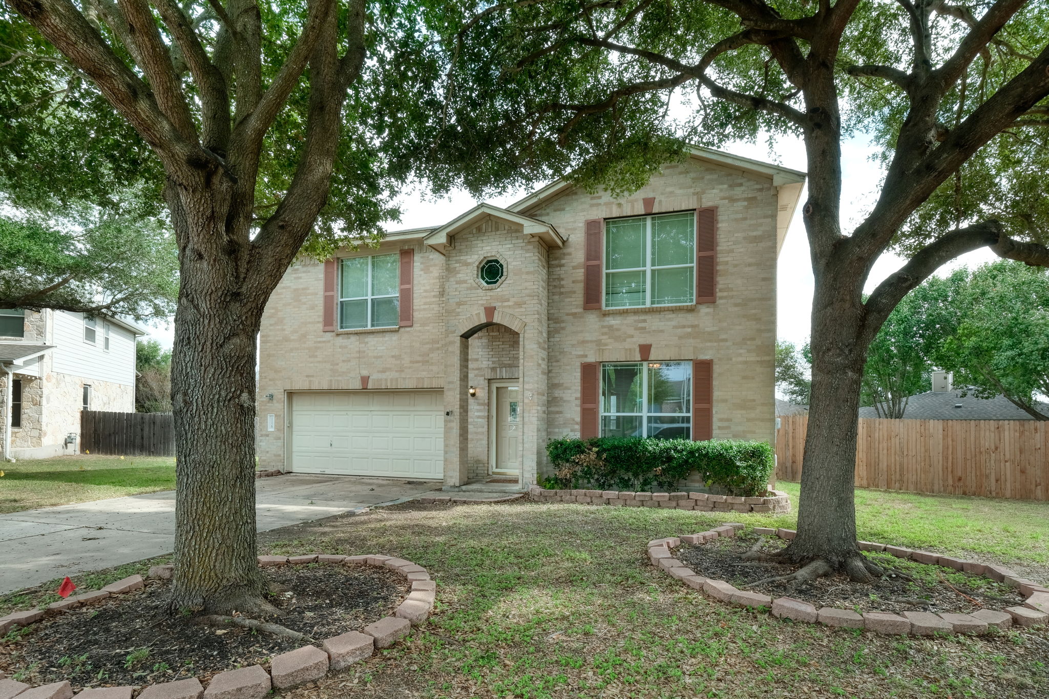 a view of a yard in front of a house with large tree