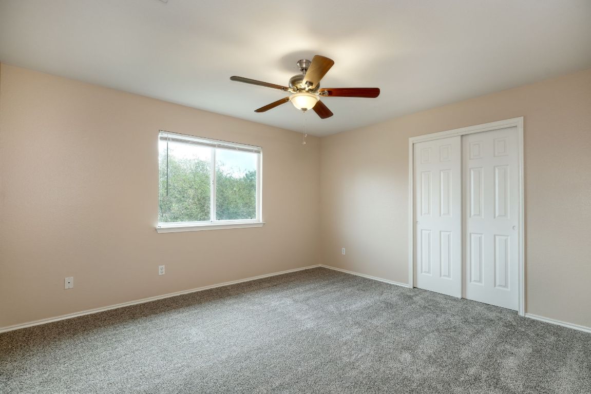 116 Rio Grande Drive Kyle, TX 78640 - Photo 11 of 13 Unfurnished bedroom featuring carpet, a ceiling fan, and a closet
