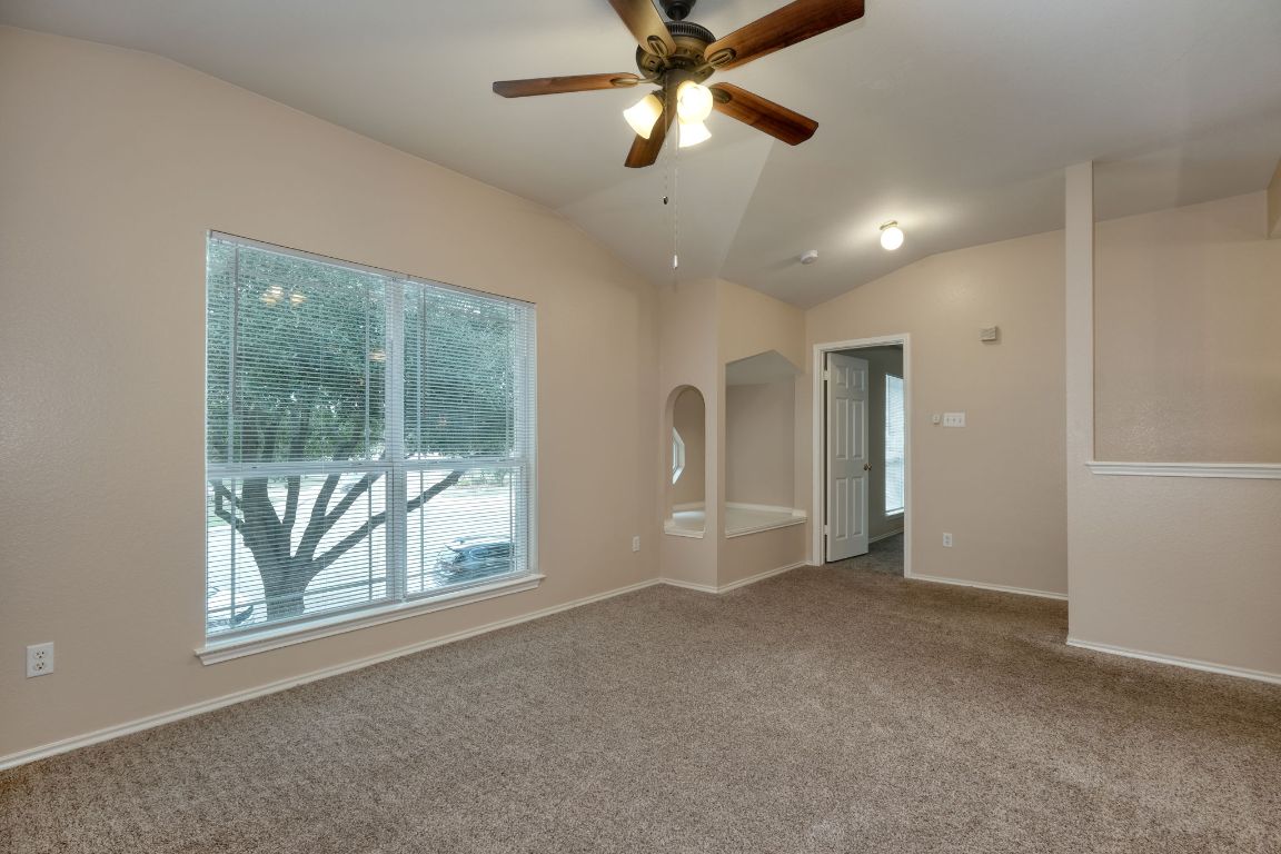 116 Rio Grande Drive Kyle, TX 78640 - Photo 6 of 13 Carpeted spare room with vaulted ceiling and ceiling fan
