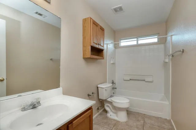 a bathroom with a granite countertop sink toilet a shower and a mirror