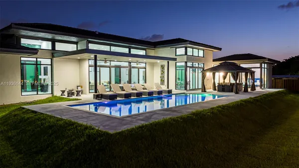 a view of a house with swimming pool and sitting area
