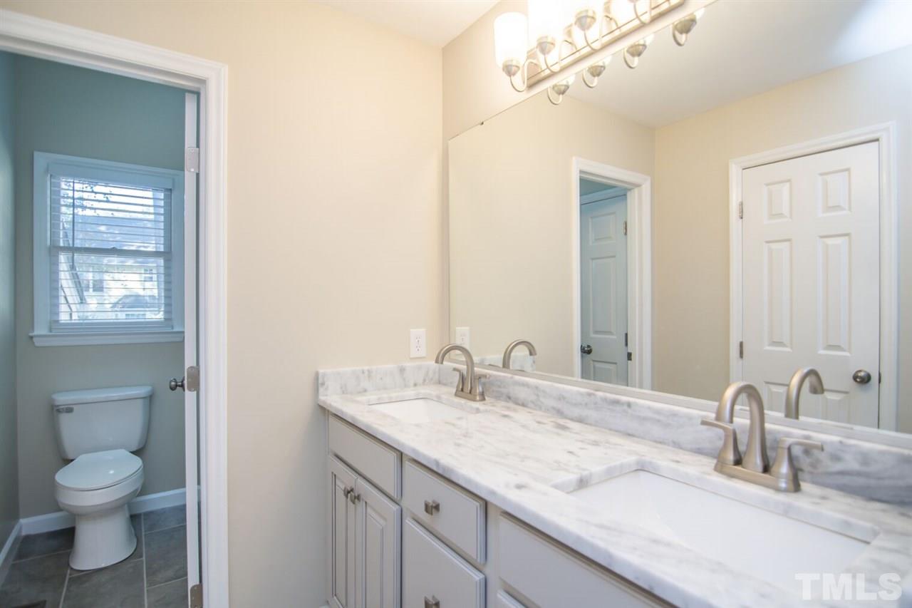 109 Boxford Road Morrisville, NC 27560 - Photo 15 of 27 a bathroom with a granite countertop toilet a sink and a mirror