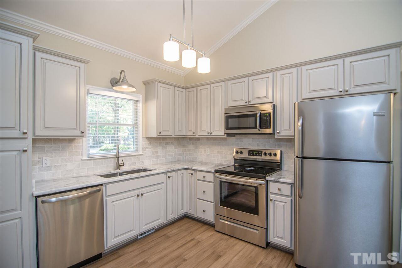 109 Boxford Road Morrisville, NC 27560 - Photo 7 of 27 a kitchen with a white cabinets and white appliances