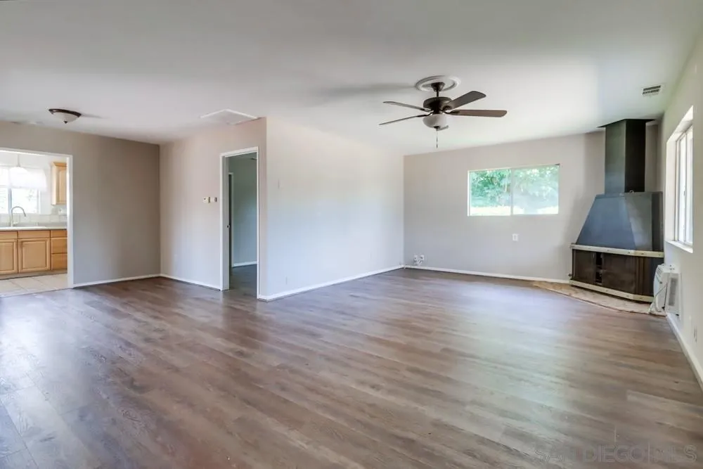 530 Mountain View Road El Cajon, CA 92021 - Photo 4 of 18 an empty room with wooden floor chandelier fan and windows