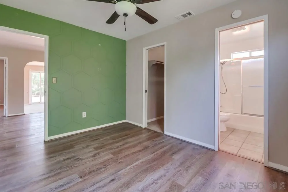 530 Mountain View Road El Cajon, CA 92021 - Photo 9 of 18 an empty room with wooden floor a ceiling fan and a window