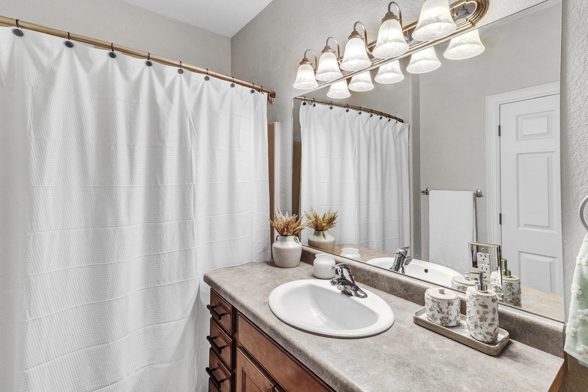 2432 Jack Creek Road Grand Junction, CO 81505 - Photo 18 of 26 a bathroom with a granite countertop sink a mirror and a shower curtain