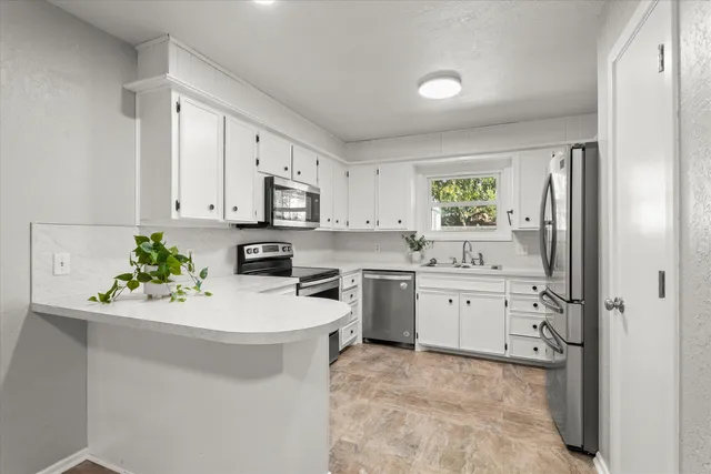 a kitchen with a sink stove and white cabinets