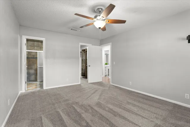 a view of an empty room with a ceiling fan