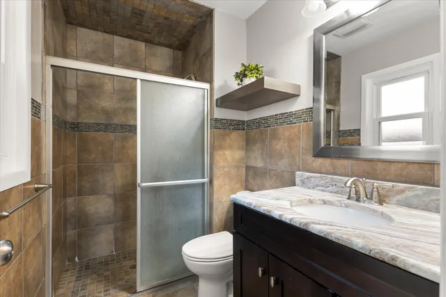 an empty room with chandelier fan and windows