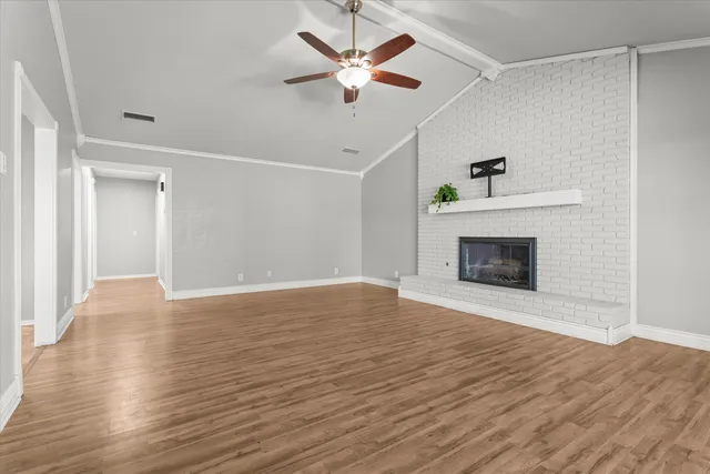 a view of empty room with wooden floor and fireplace
