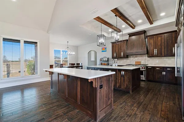 a kitchen with a sink stove cabinets and wooden floor