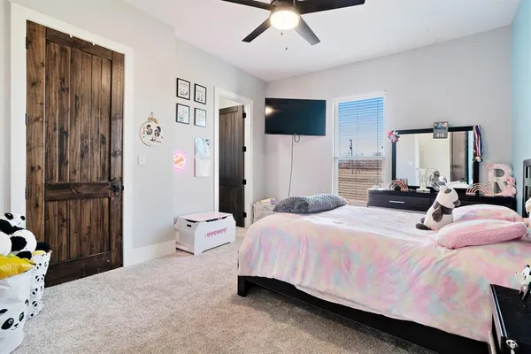 a bedroom with a bed bathroom and flat screen tv