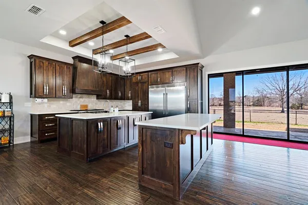 a kitchen with stainless steel appliances granite countertop a stove and a wooden floors
