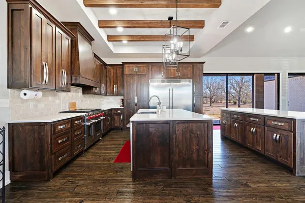 a kitchen with stainless steel appliances granite countertop a large stove a sink dishwasher and cabinets with wooden floor