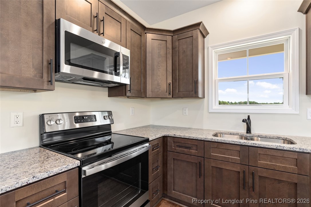 111 Merle Road Pinebluff, NC 28373 - Photo 11 of 32 a kitchen with stainless steel appliances a sink a stove and microwave