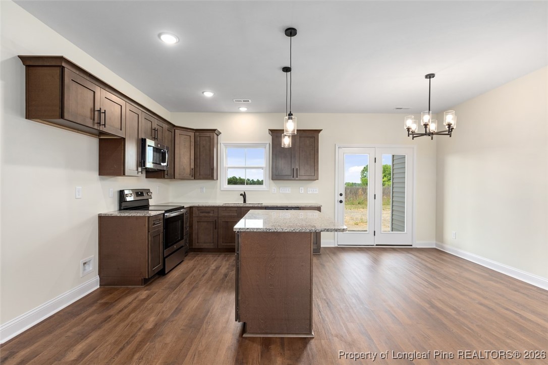 111 Merle Road Pinebluff, NC 28373 - Photo 19 of 32 a kitchen with a refrigerator a sink dishwasher a kitchen island with wooden floor and cabinets