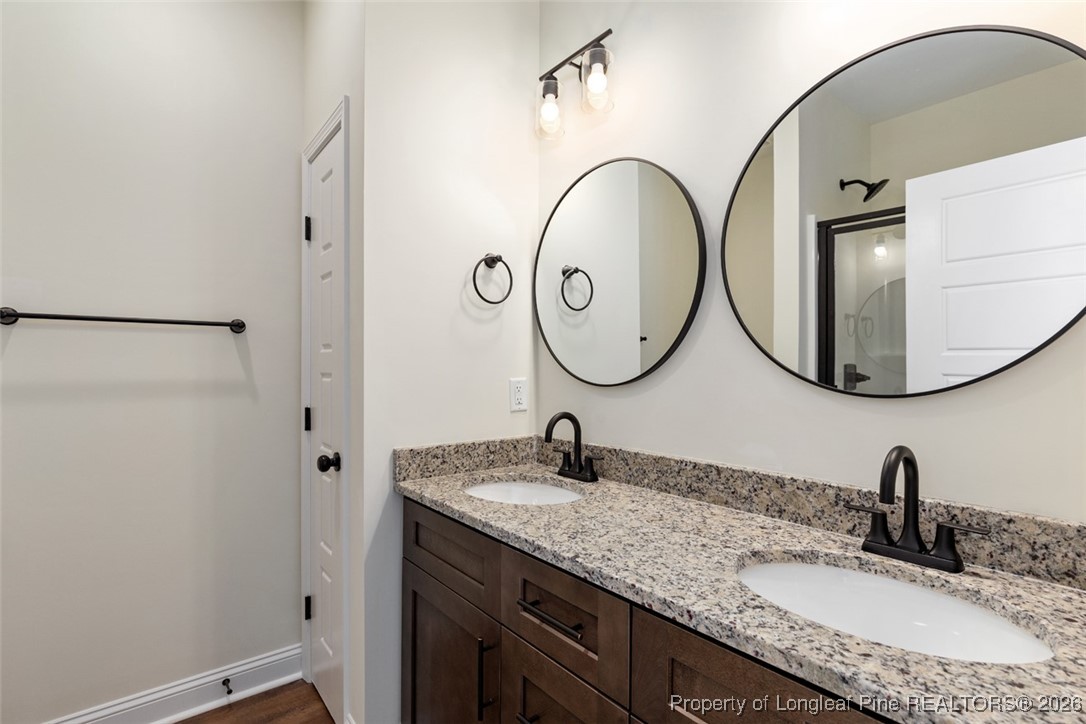 111 Merle Road Pinebluff, NC 28373 - Photo 20 of 32 a bathroom with a granite countertop sink a mirror and a shower